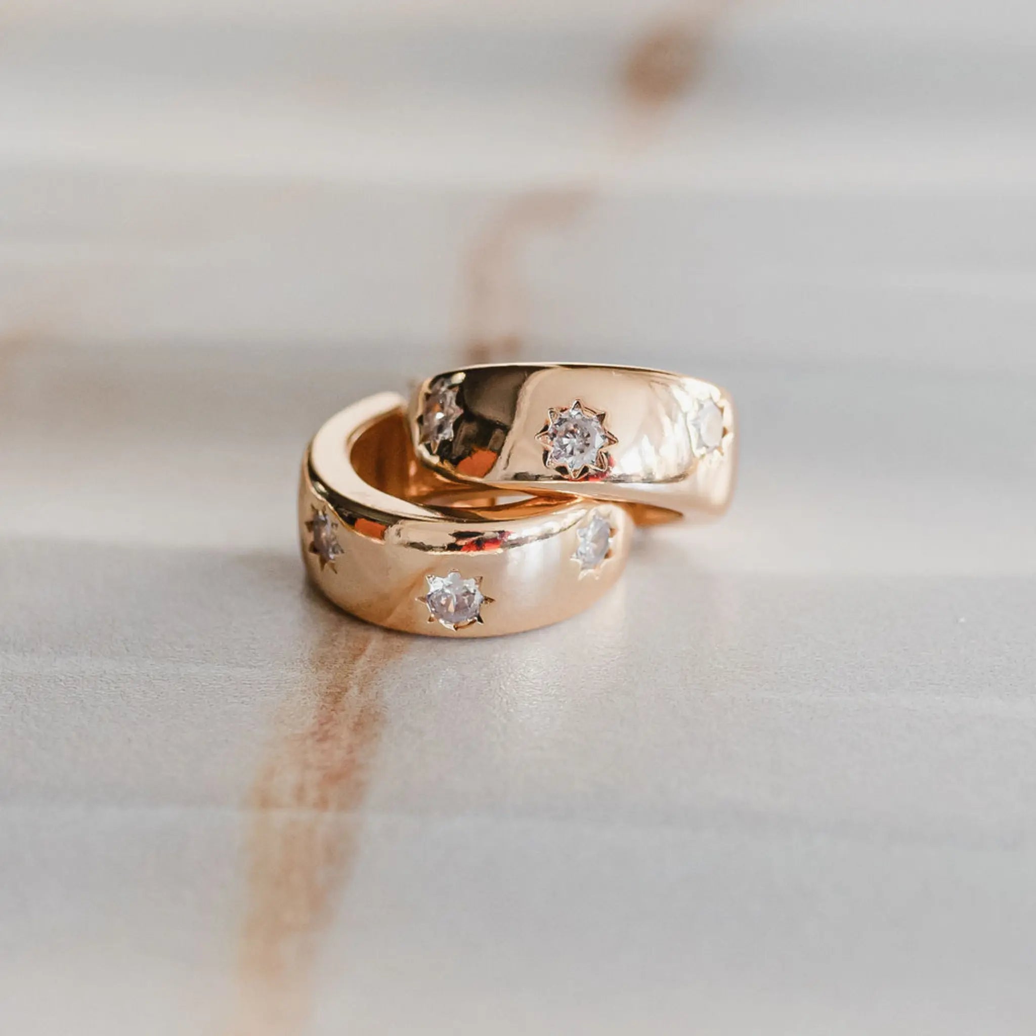 chunky gold huggie hoops with CZ star detail