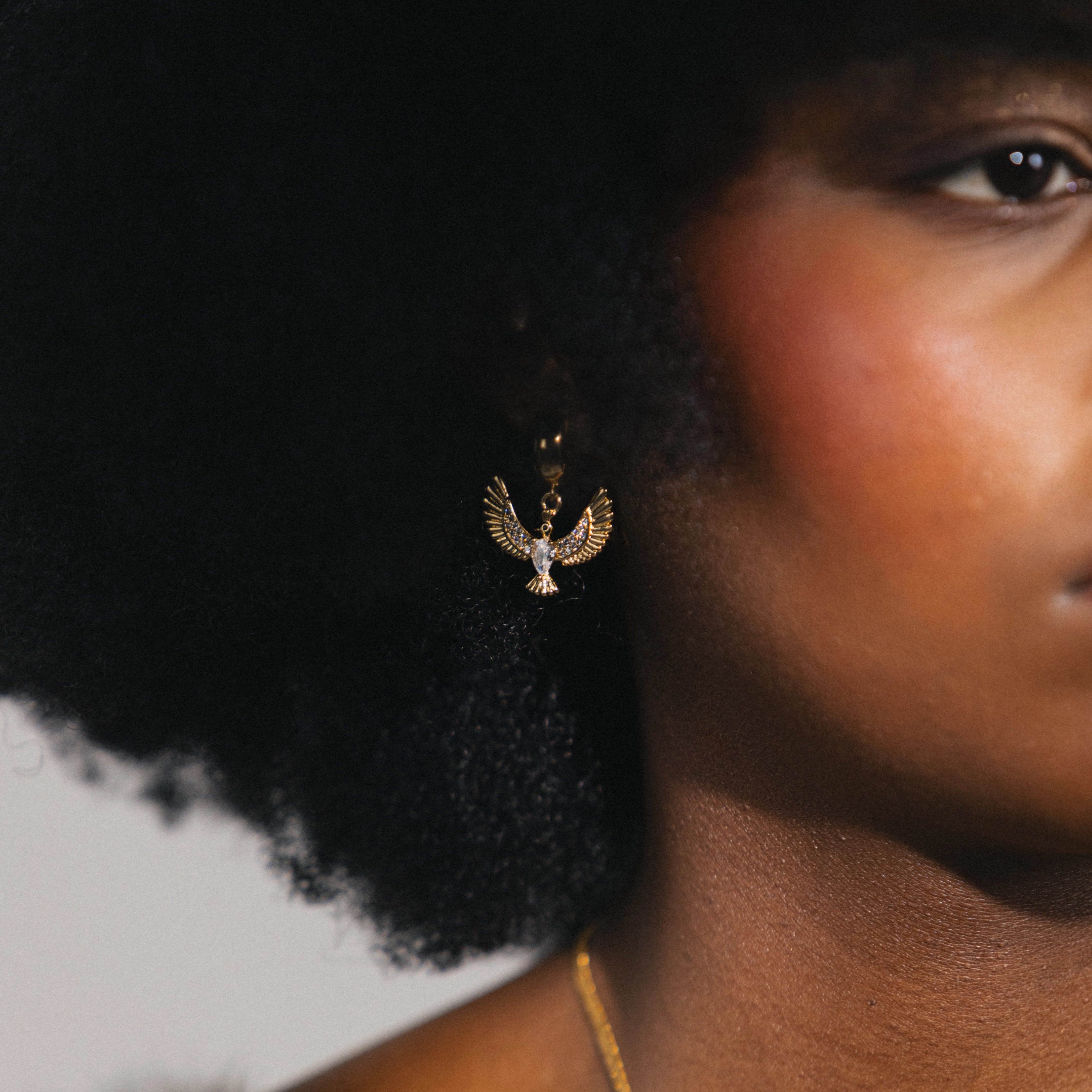 gold huggie hoops with bird charm