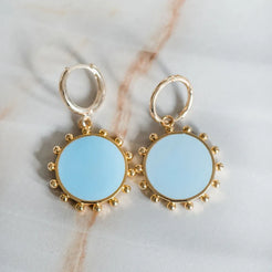 Blue round charm on gold huggie earring