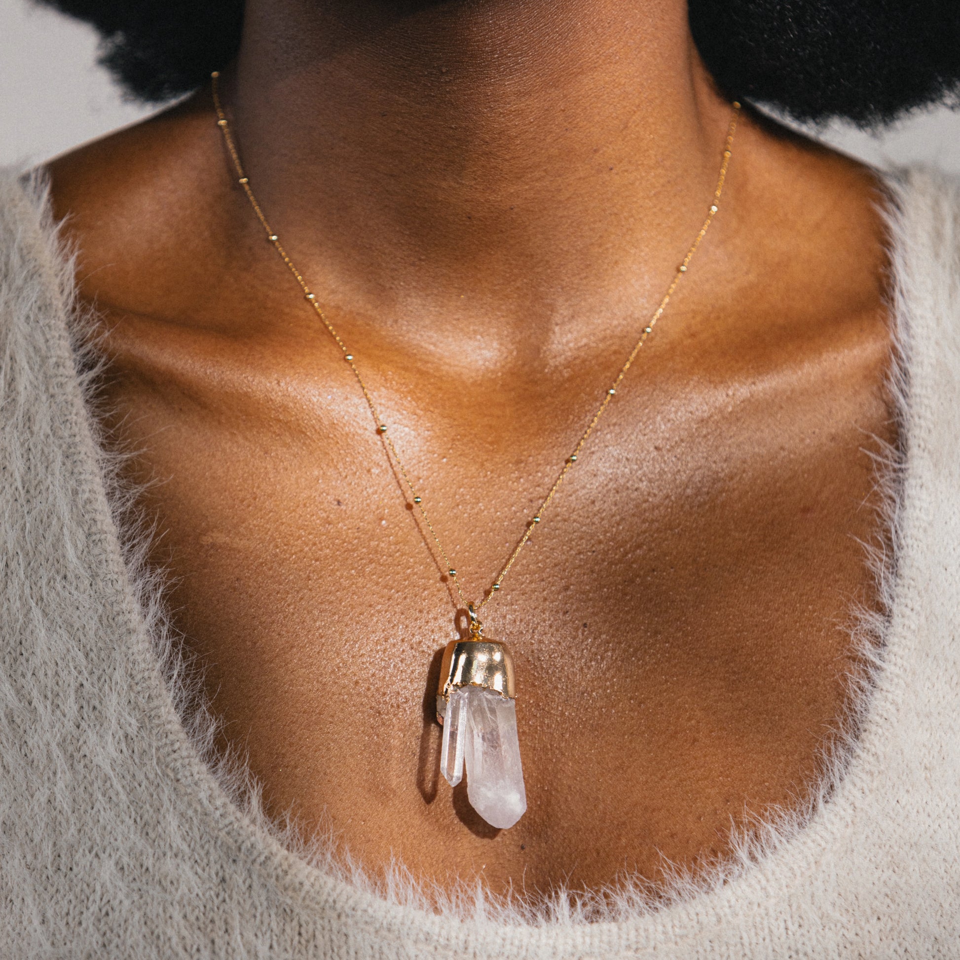 clear quartz pendant on gold necklace 