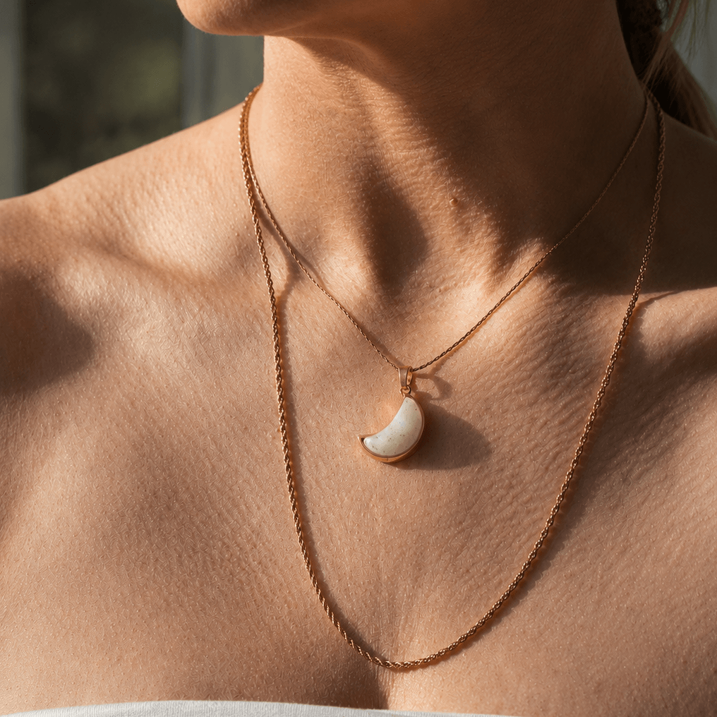 Necklace with a crescent moon pendant on a person's neck