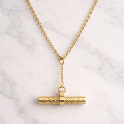 Gold necklace with a cylindrical pendant on a marble background